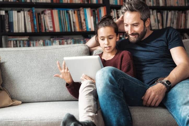 dad watching video with daughter on ipad