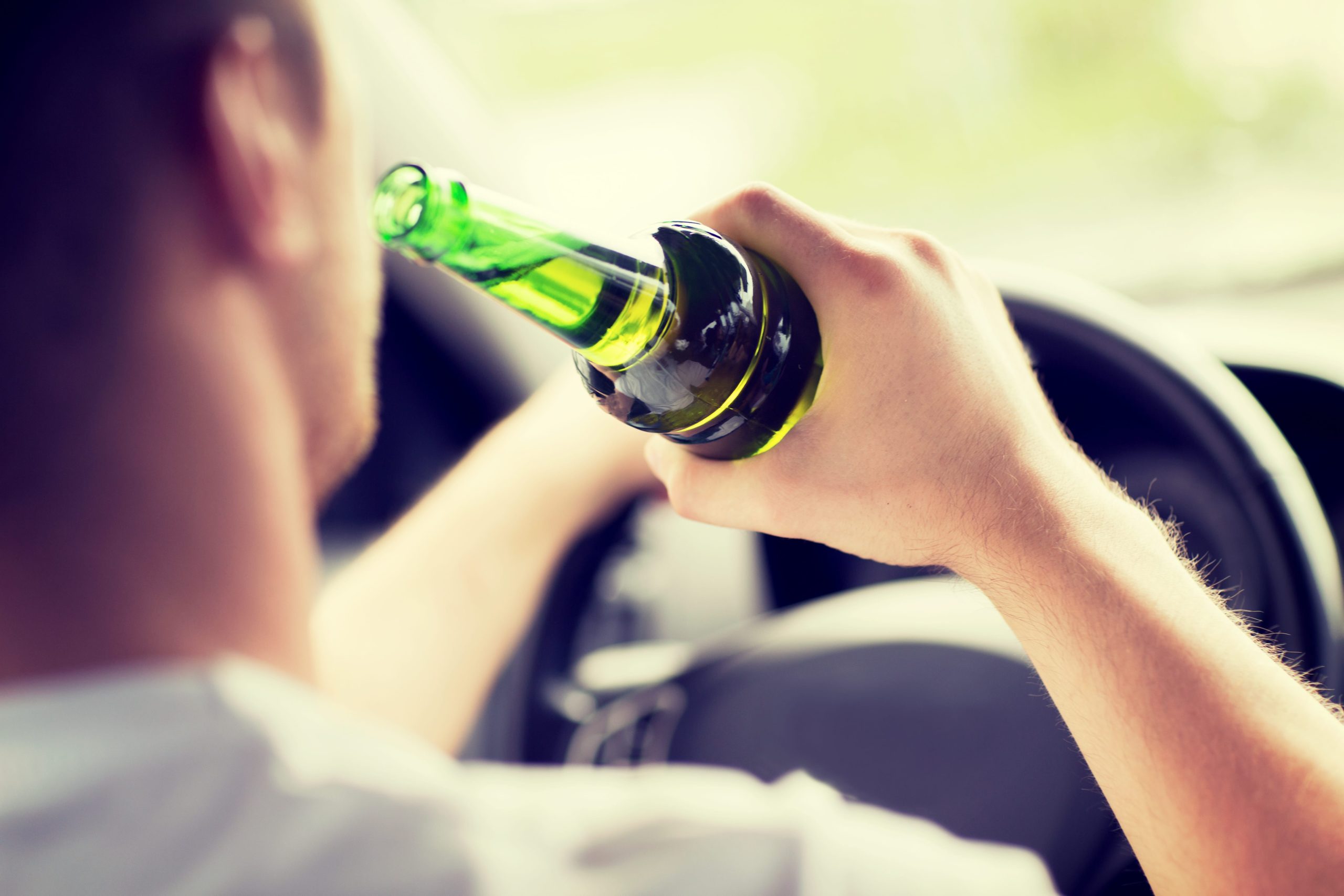 Man drinking beer while driving