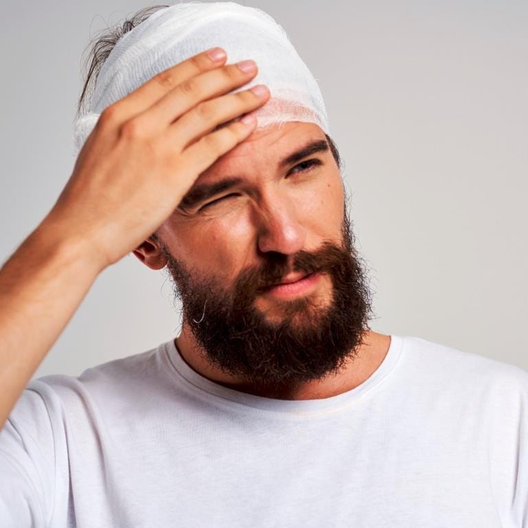 Man holding bandaged head