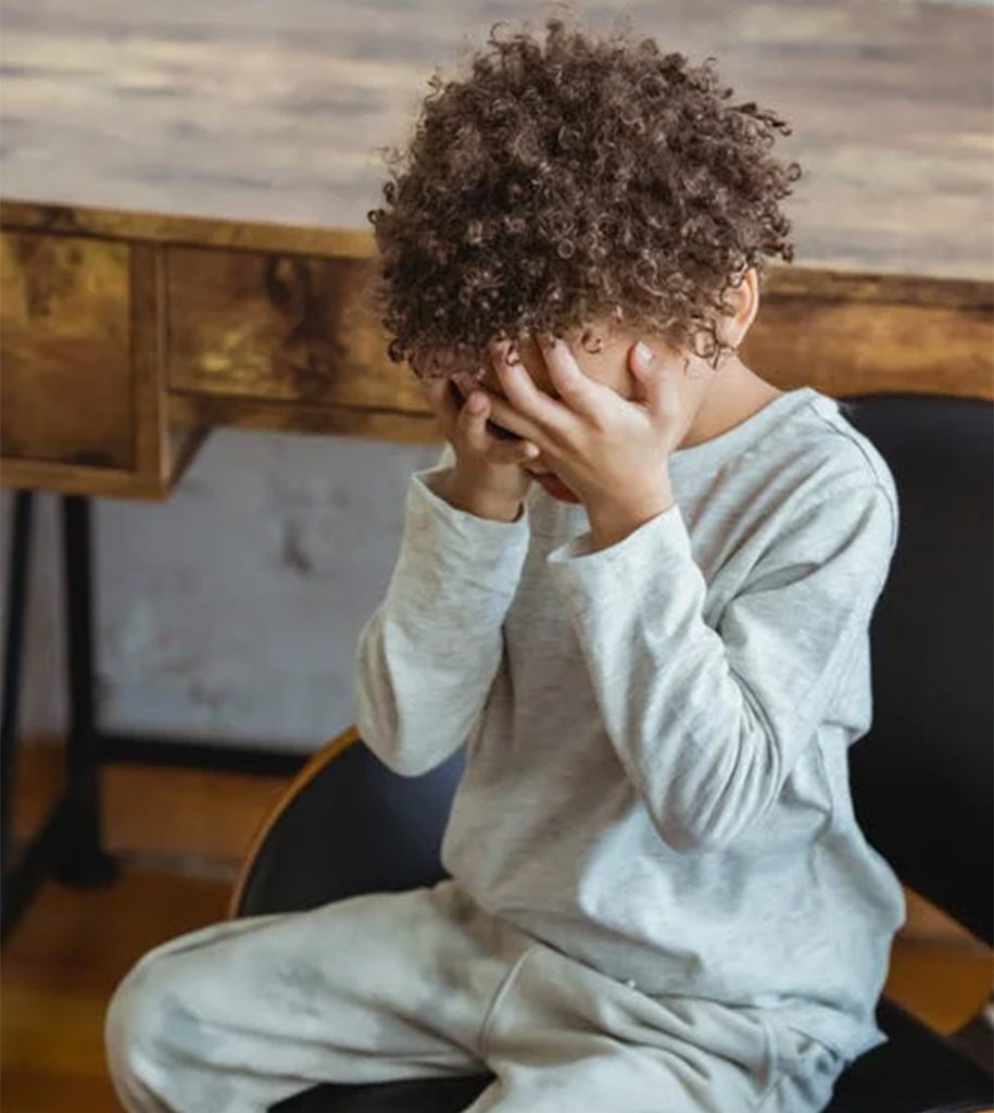 a child covering his face