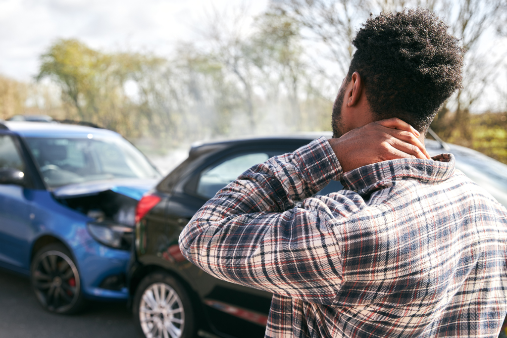 a person holding their neck after a car accident